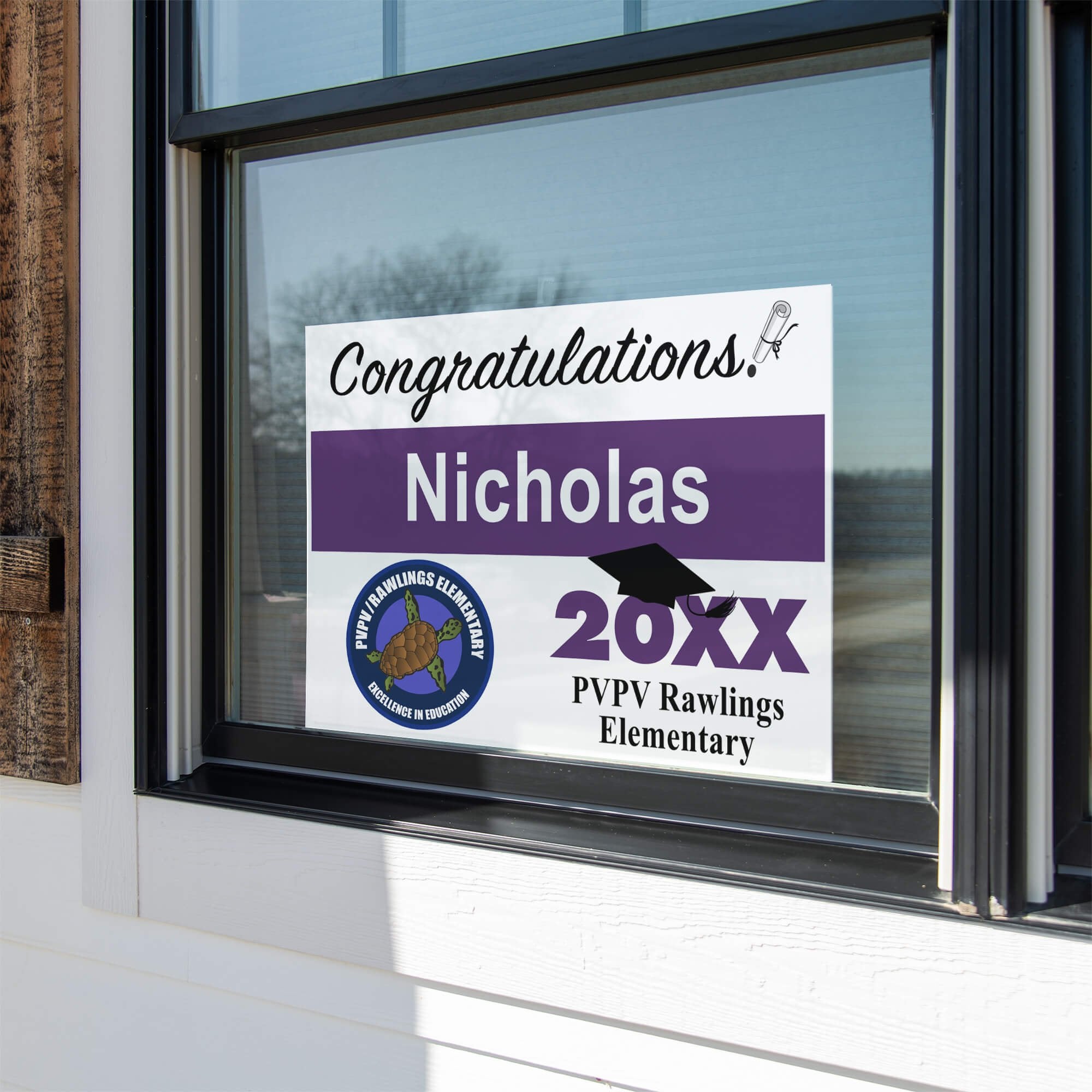 School logo graduation yard sign displayed in a window