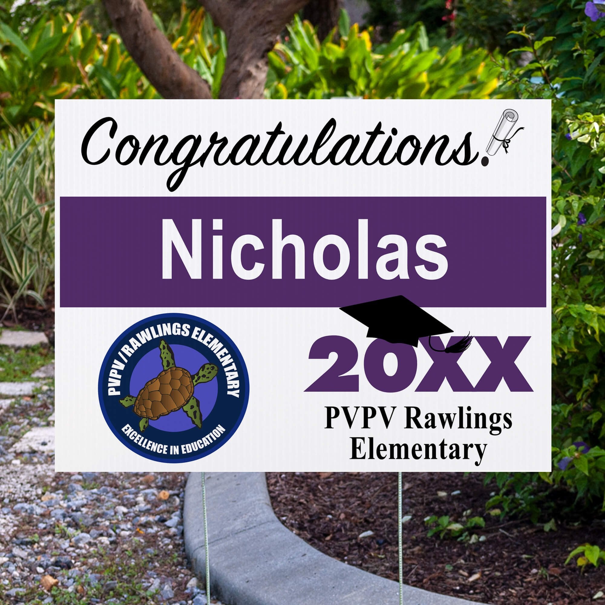 School logo graduation yard sign displayed next to pavement