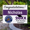 School logo graduation yard sign displayed next to pavement