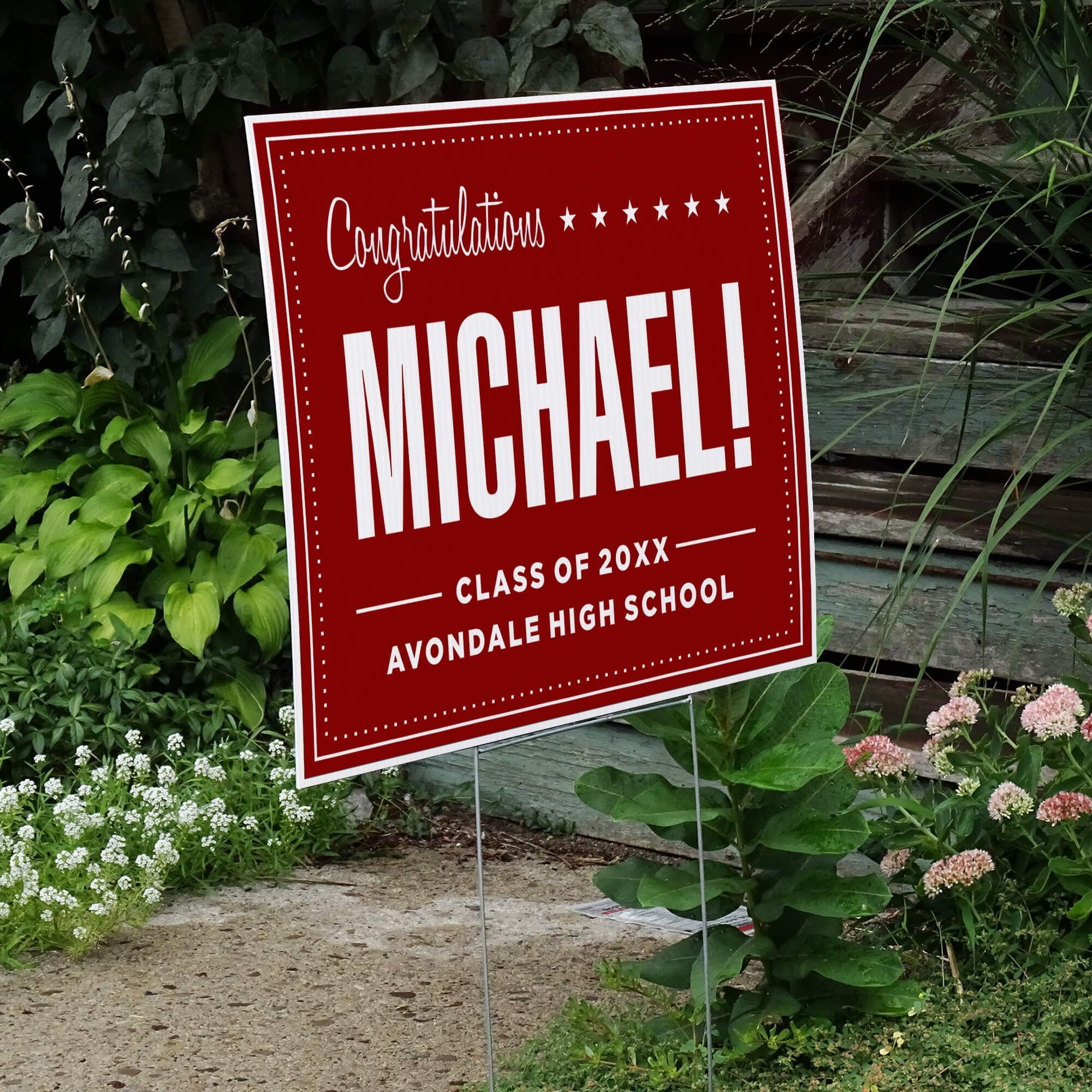 Bold name graduation yard sign displayed next to stairs