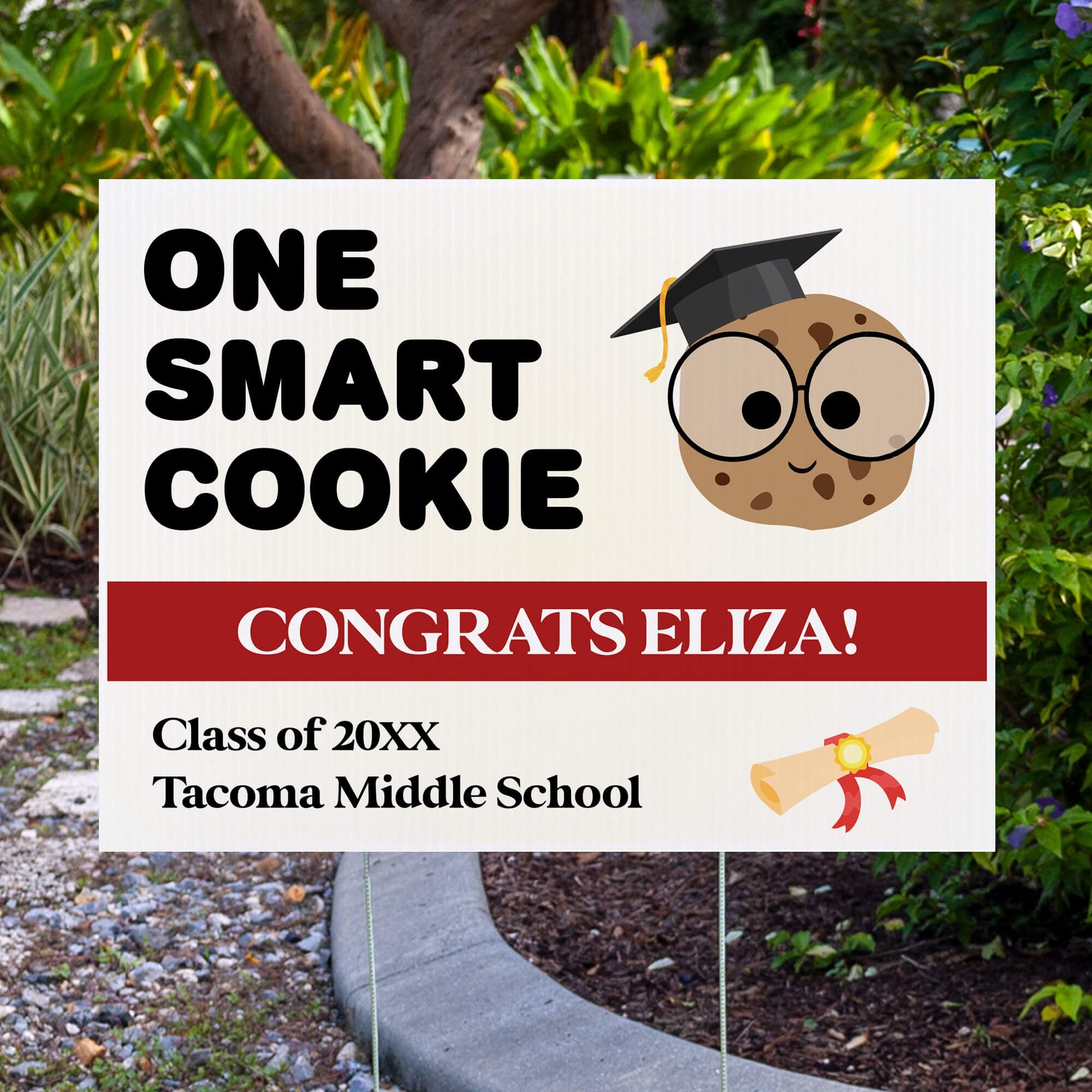 graduation yard sign displayed next to pavement