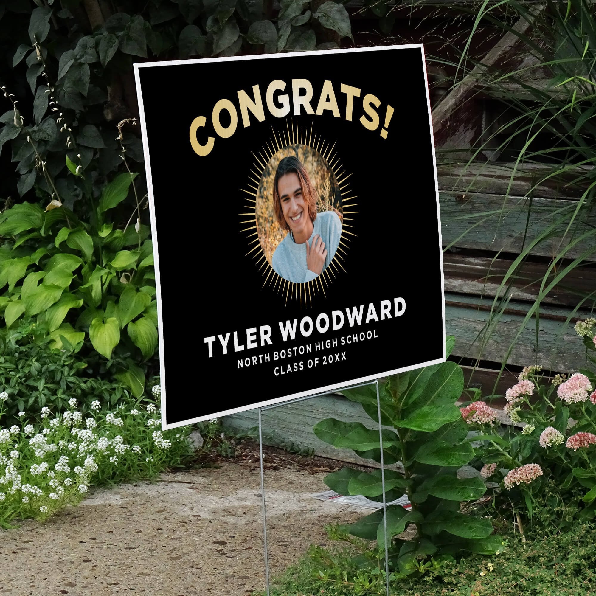 Sunburst graduation yard sign displayed next to stairs