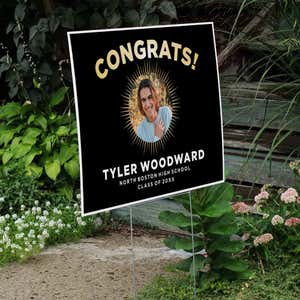 Sunburst graduation yard sign displayed next to stairs