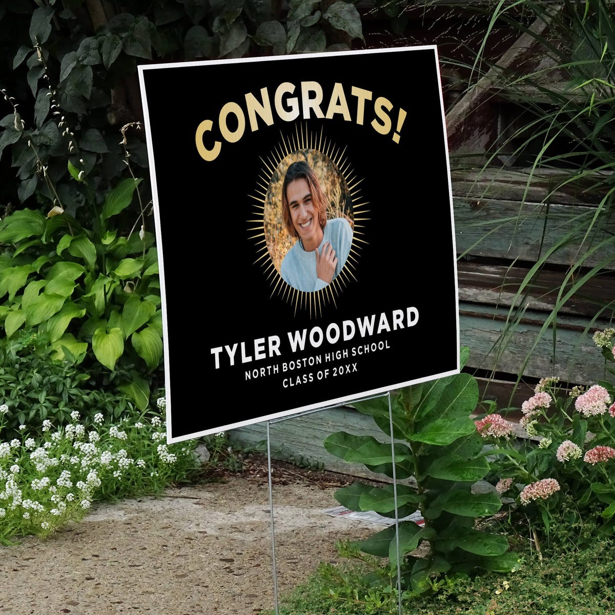 Sunburst graduation yard sign displayed next to stairs