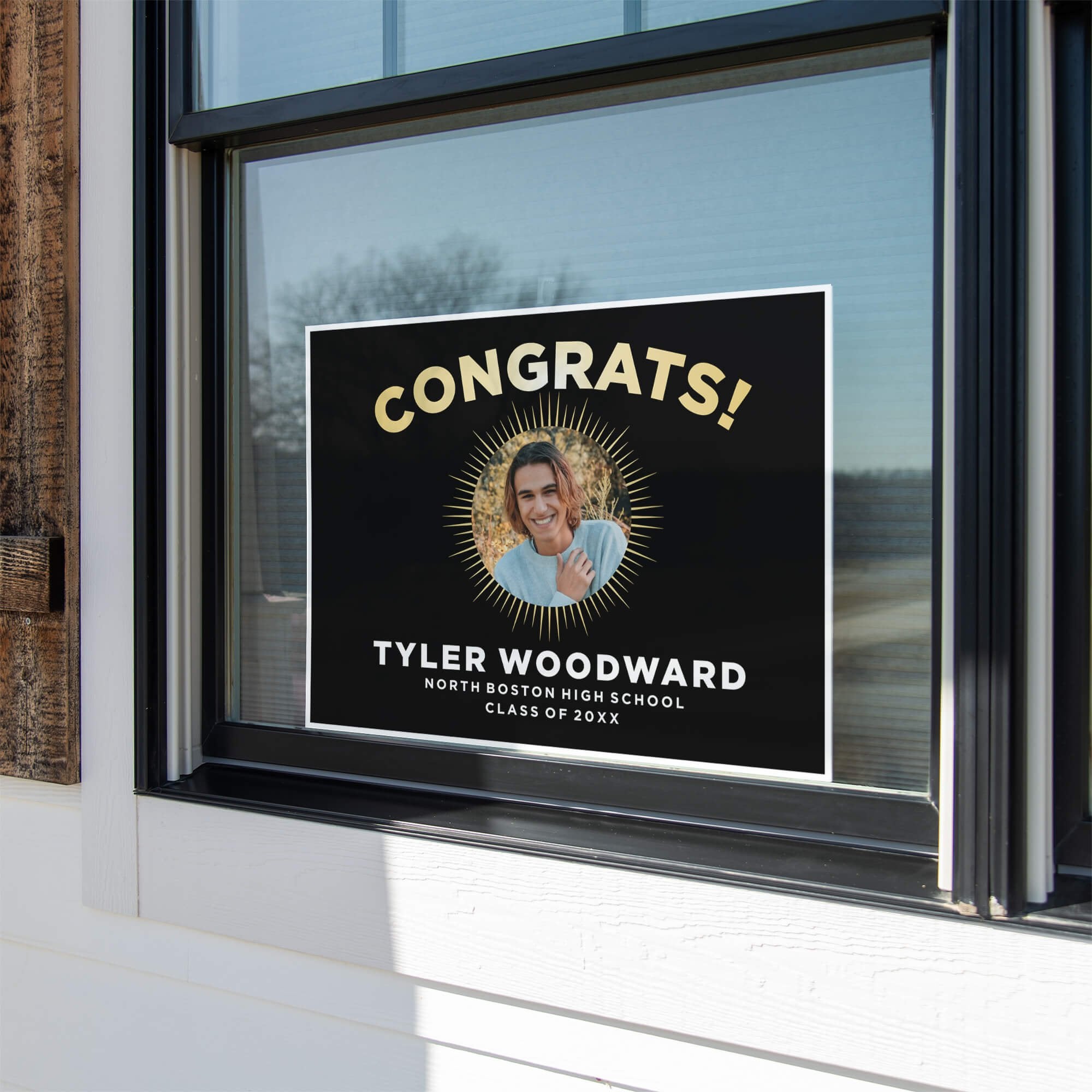 Sunburst graduation yard sign displayed in a window