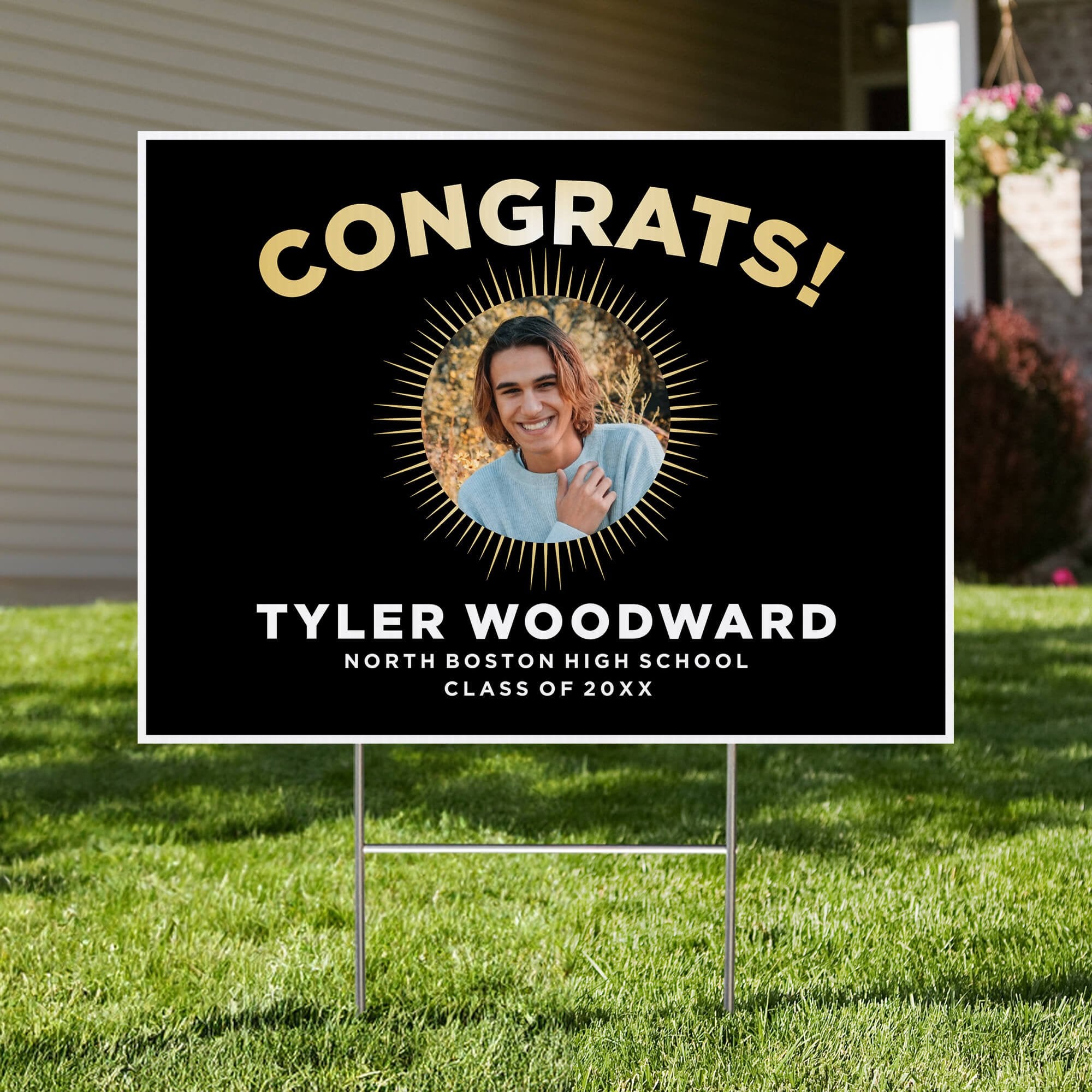 Sunburst graduation yard sign displayed in a front yard