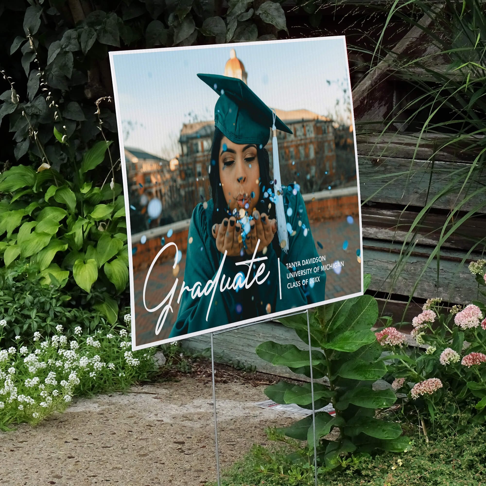 Full photo graduation yard sign displayed next to stairs