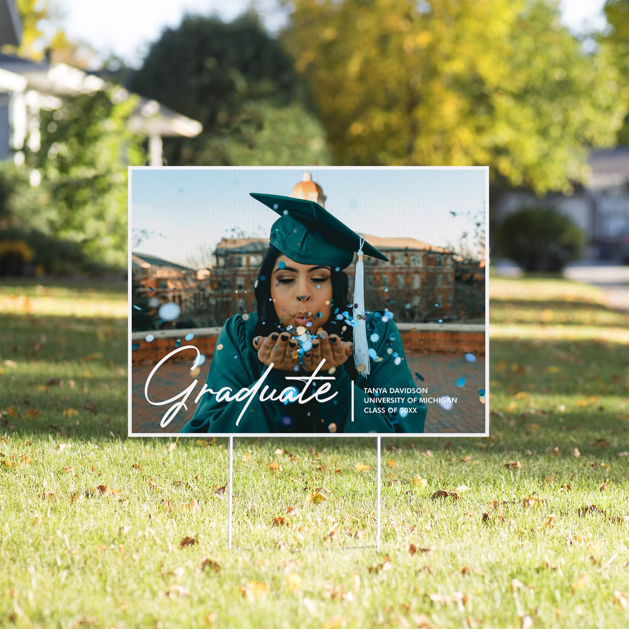 Full photo graduation yard sign displayed in a sunny yard