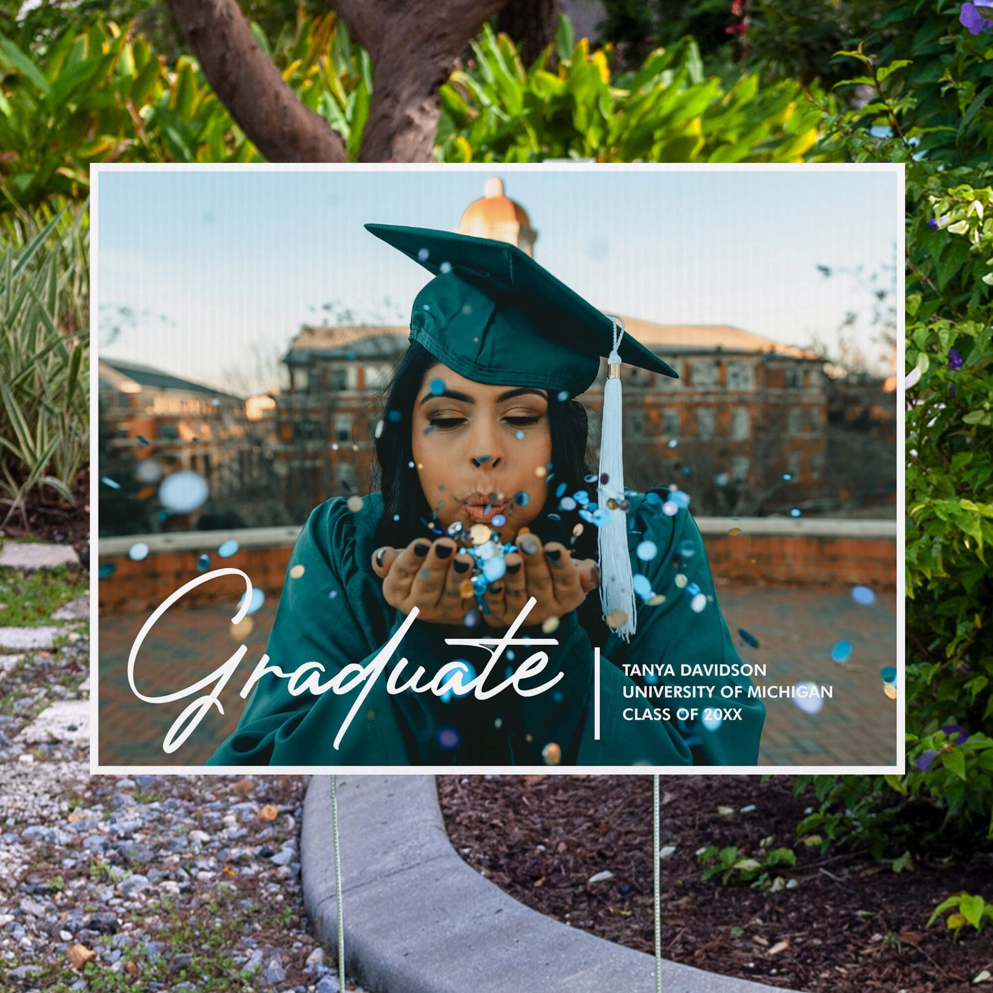 Full photo graduation yard sign displayed next to pavement