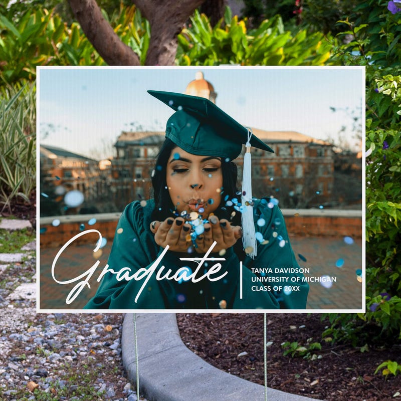 Full photo graduation yard sign displayed next to pavement