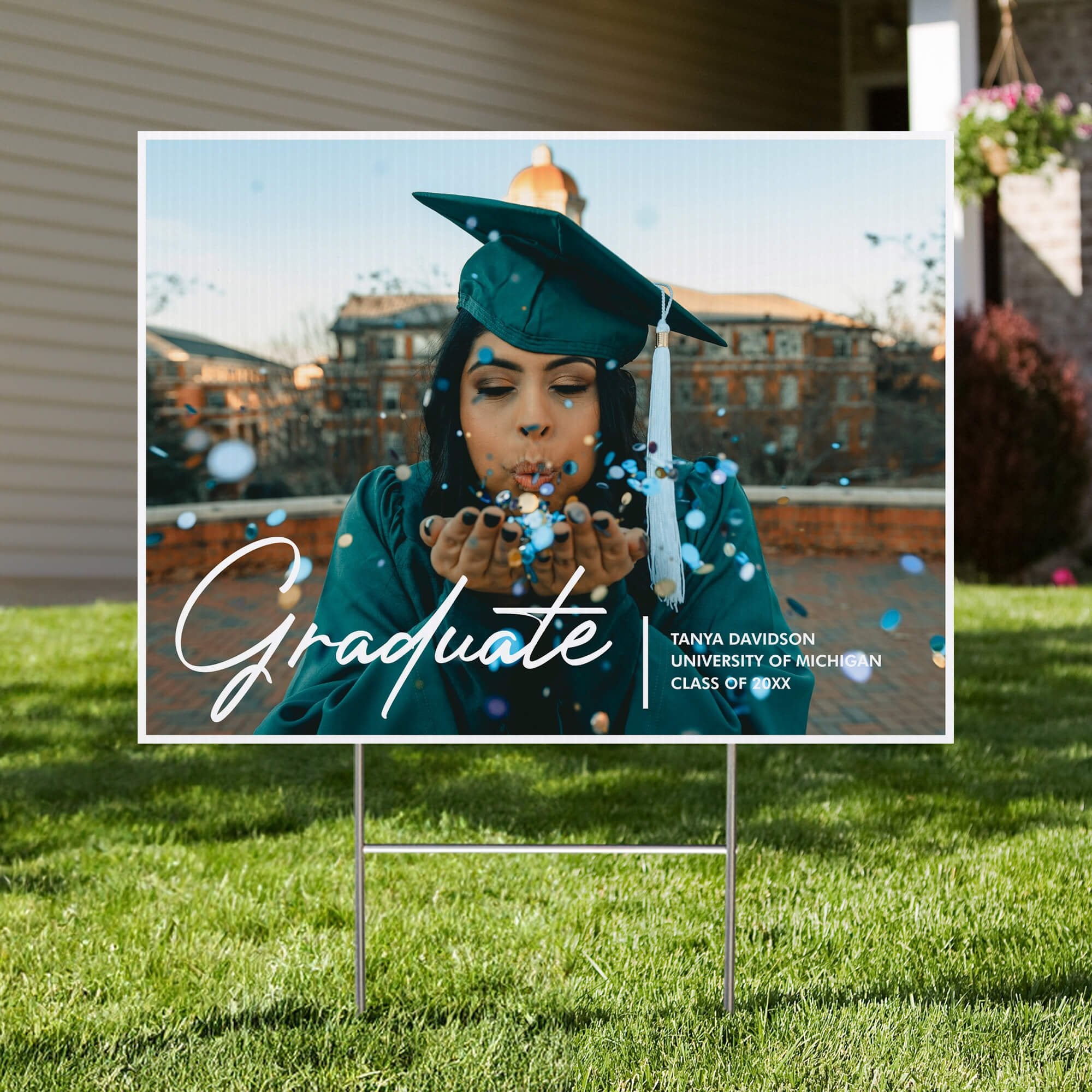 Full photo graduation yard sign displayed in a front yard