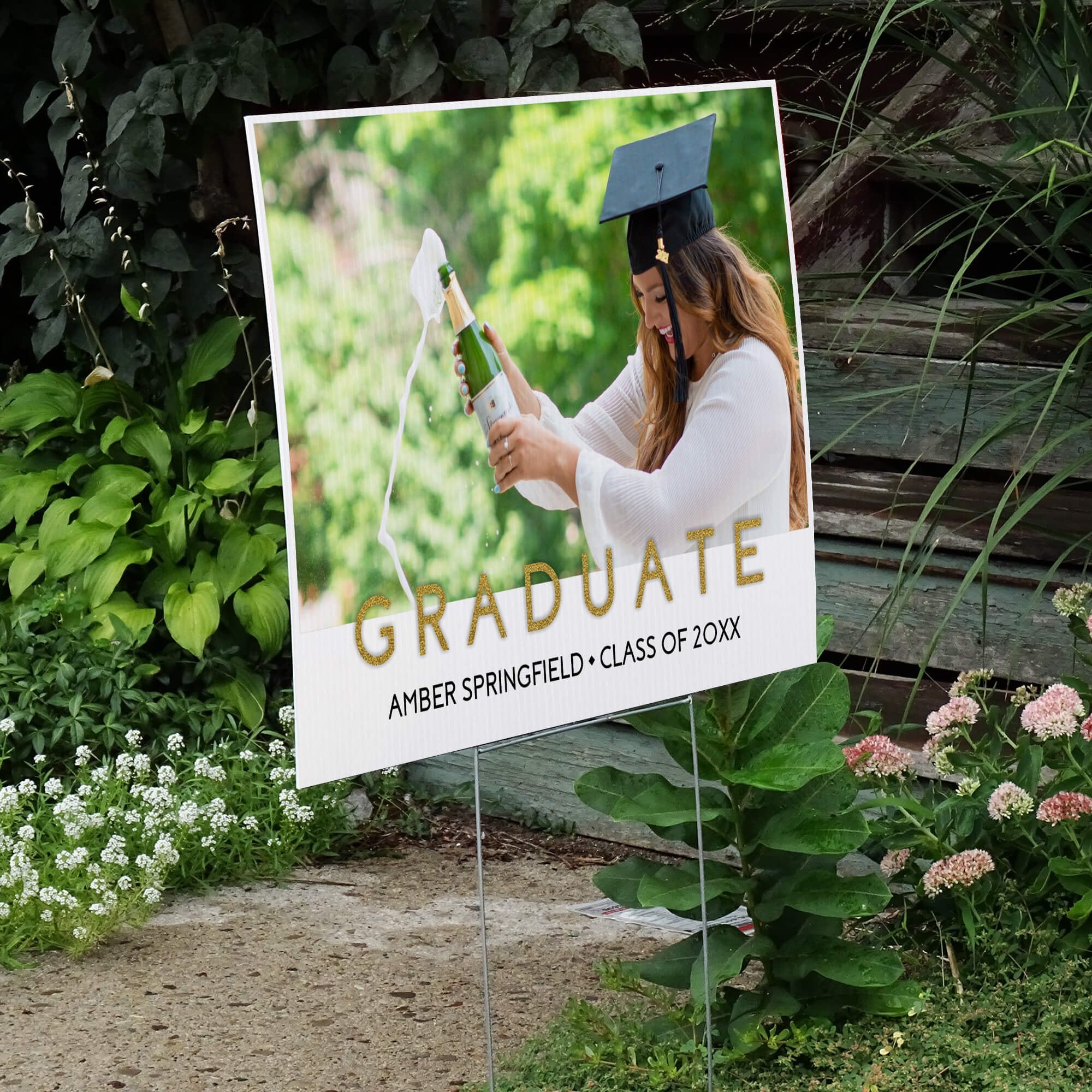 Gold text graduation yard sign displayed next to stairs