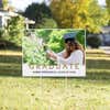 Gold text graduation yard sign displayed on a sunny yard