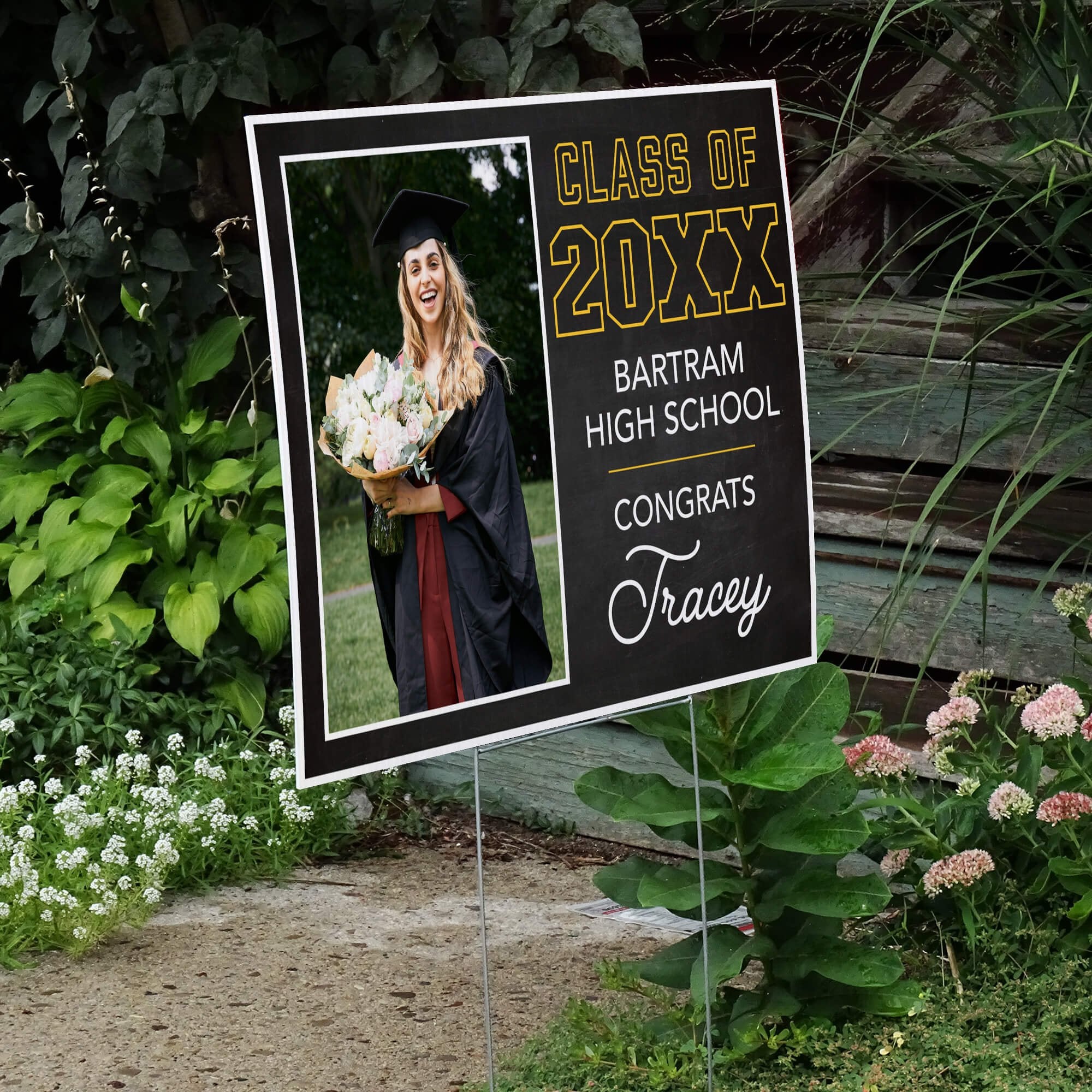 Chalkboard Design Graduation Yard Sign displayed by a pathway leading to stairs