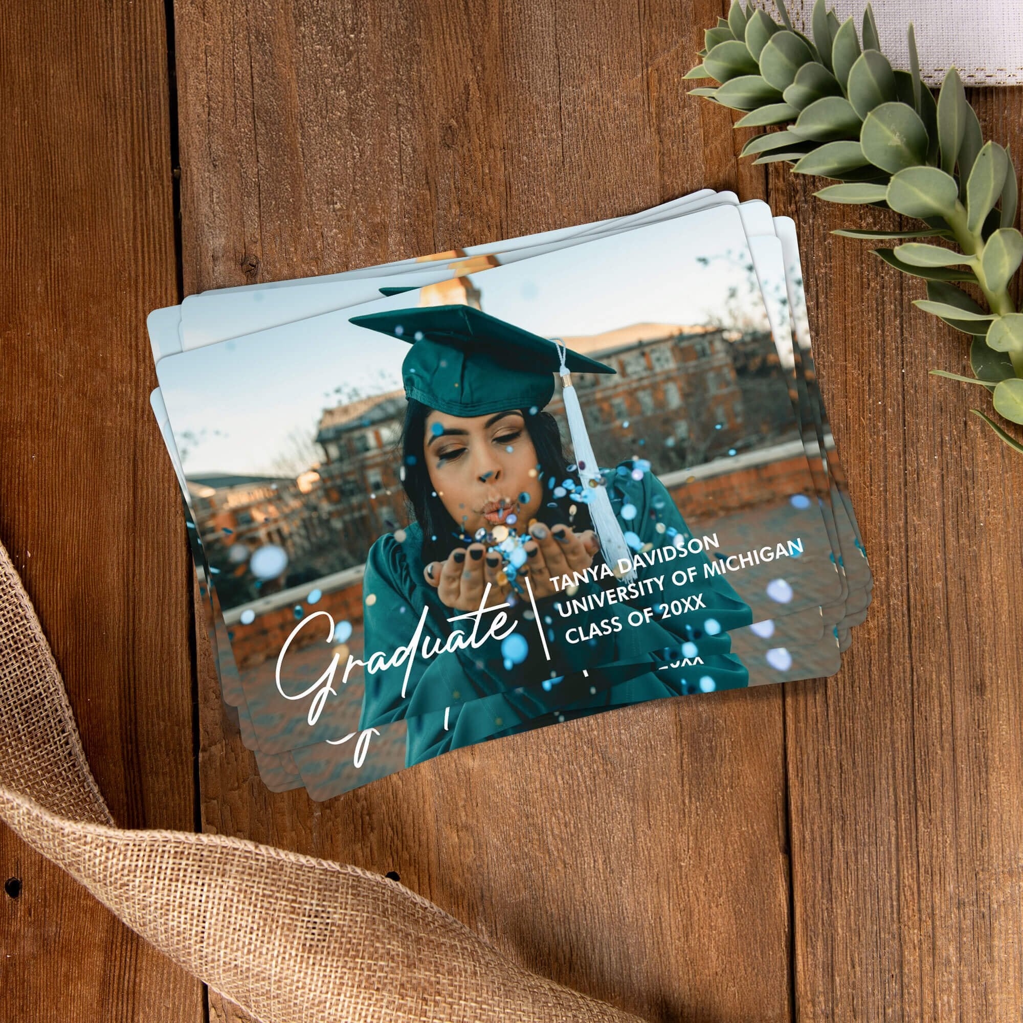 Stack of personalized Custom Photo Graduation Announcement photo magnets on a wooden table
