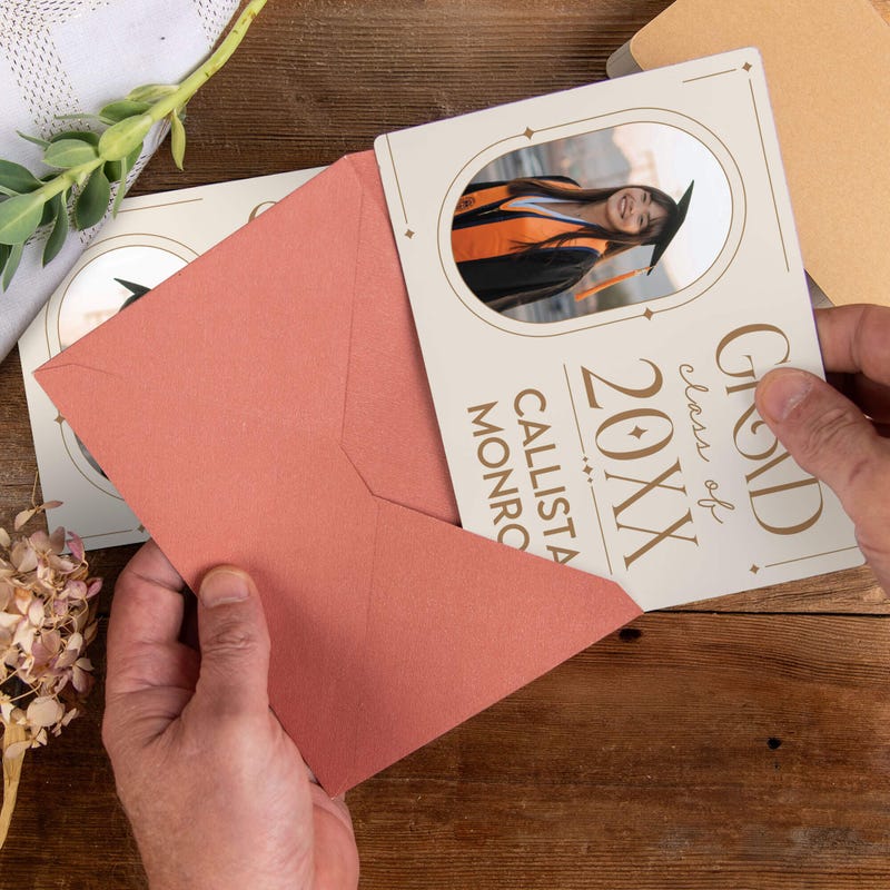 Personalized Modern Minimalist Graduation Announcement photo magnet being placed into a rose colored envelope