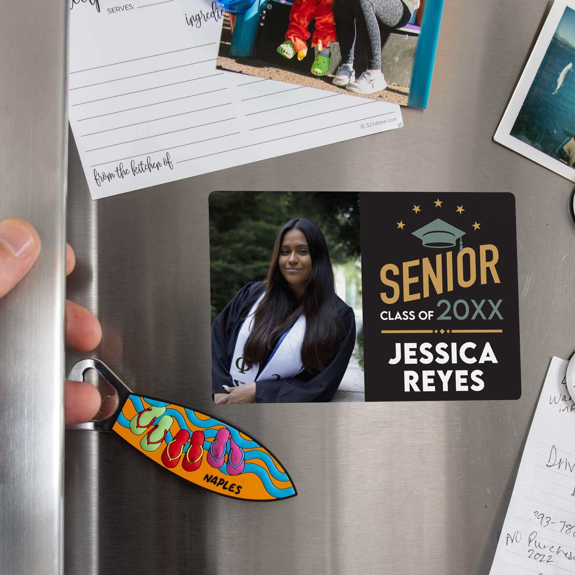 Hand placing a custom Modern Design Senior Graduation Announcement magnet on a stainless steel refrigerator
