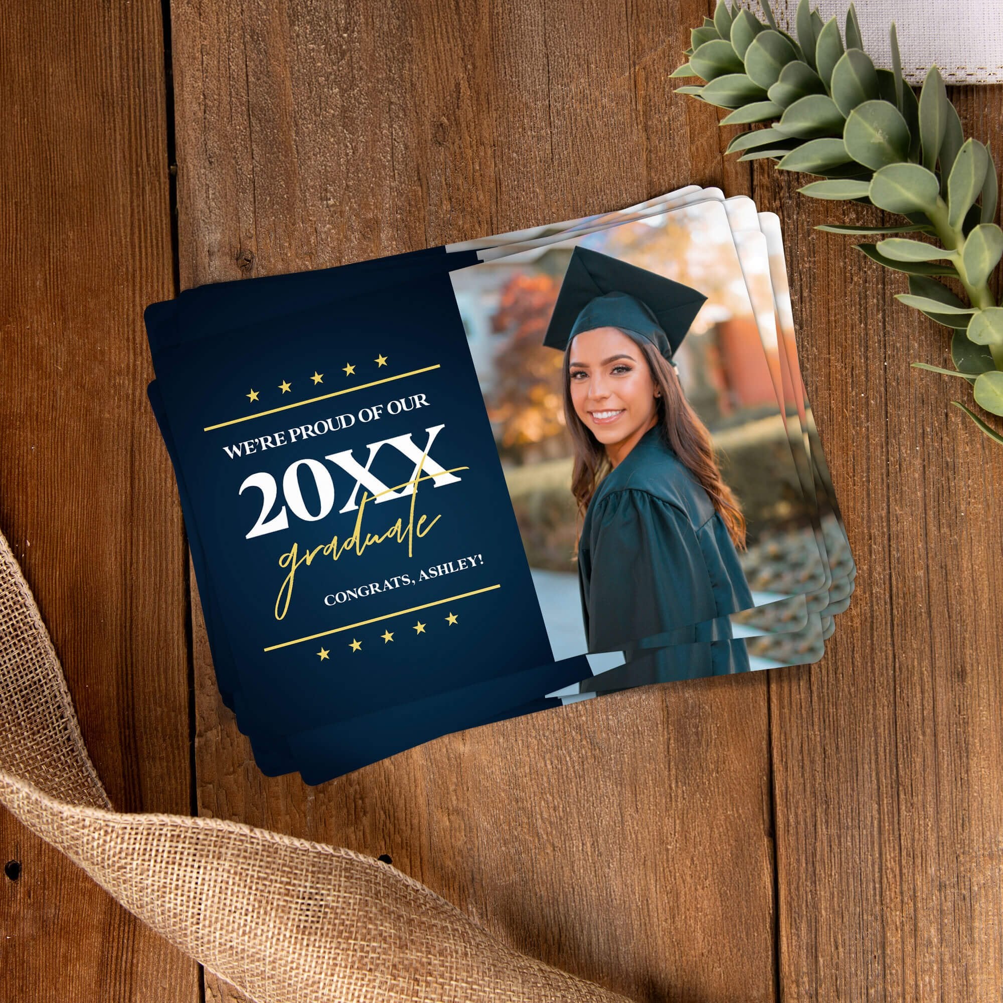 Stack of personalized graduation photo magnets on a wooden table