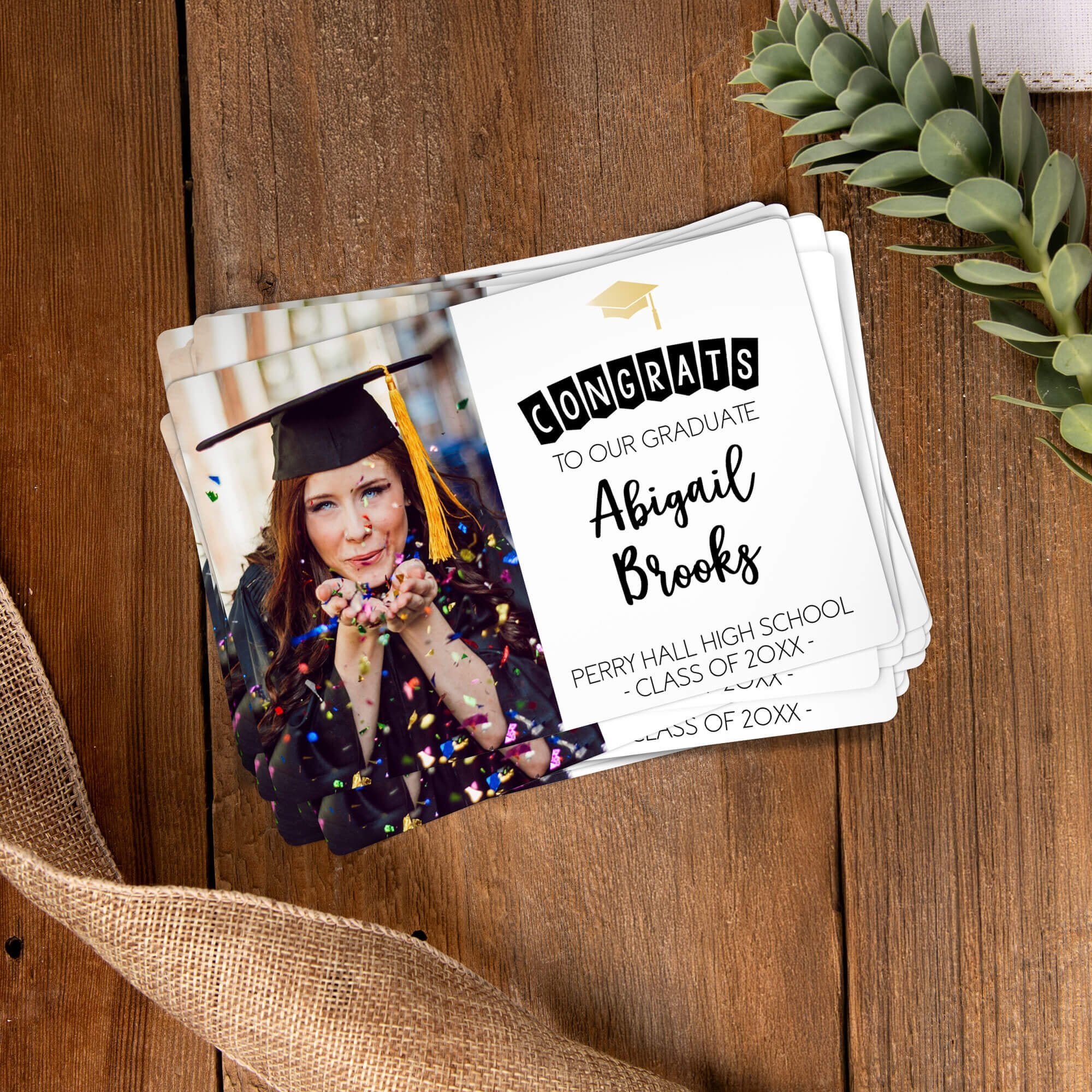 Stack of personalized graduation photo magnets on a wooden table