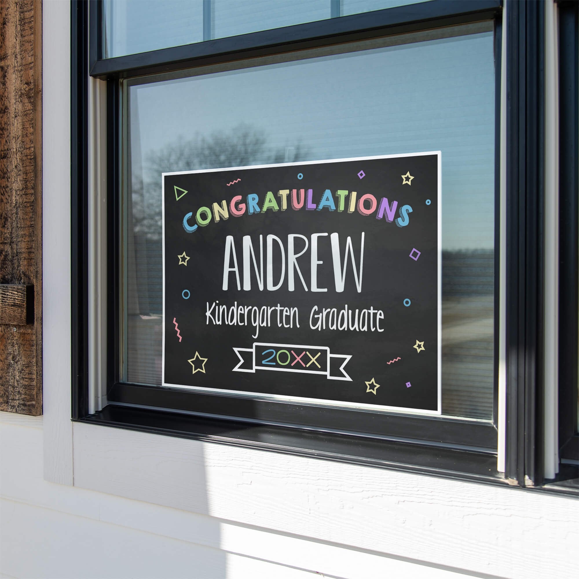 Colorful kindergarten graduation yard sign displayed in a window