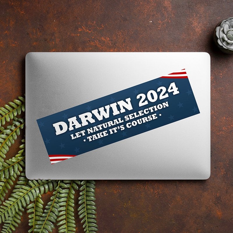 Darwin Political Bumper Sticker on a closed laptop