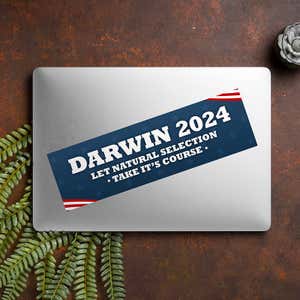 Darwin Political Bumper Sticker on a closed laptop
