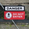 Danger Do Not Enter sign with skull image with red background with bold white and black text.