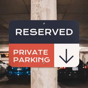 Custom reserved private parking sign with navy, red and white background with downward-pointing arrow