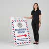 Woman standing beside a barber shop A-frame sign for scale