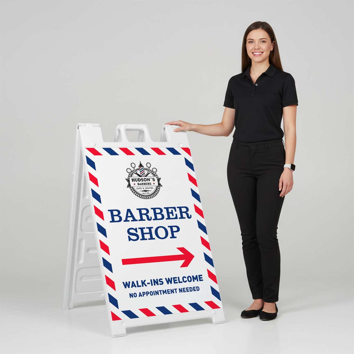 Woman standing beside a barber shop A-frame sign for scale