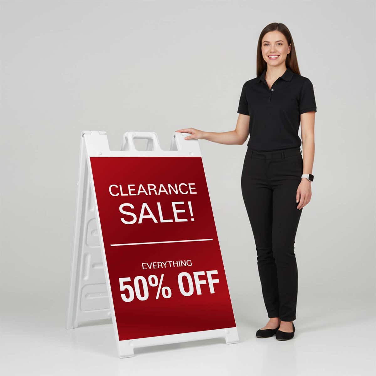Woman standing beside a clearance A-frame sign for scale