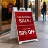 Clearance A-frame sidewalk sign displayed in front of a shop