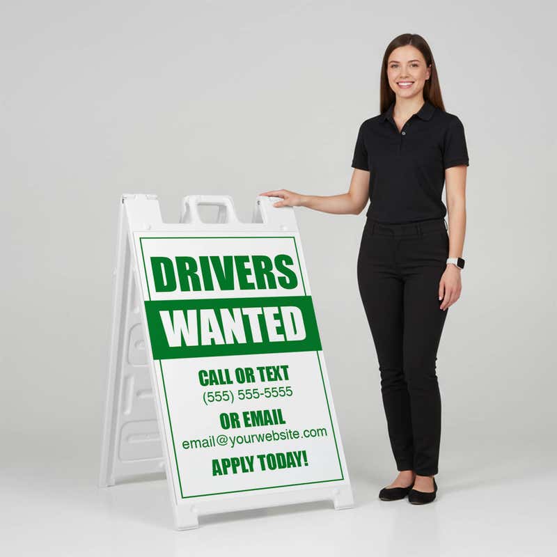 Woman standing beside a drivers wanted A-frame sign for scale