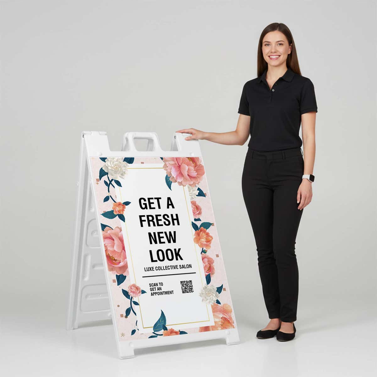 Woman standing beside a fresh look salon A-frame sign for scale