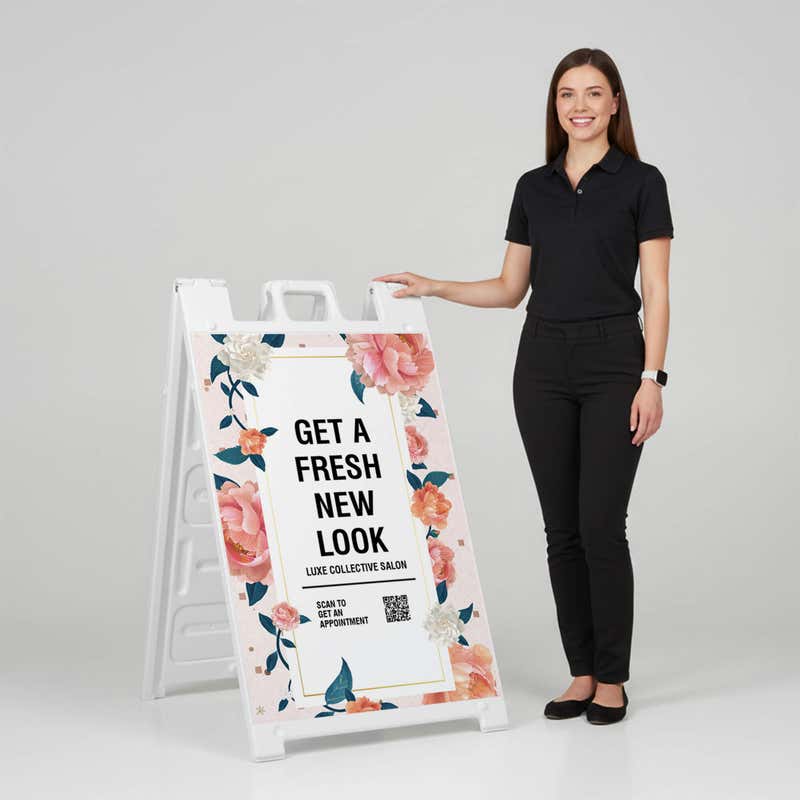 Woman standing beside a fresh look salon A-frame sign for scale