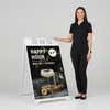Woman standing beside a happy hour A-frame sign for scale