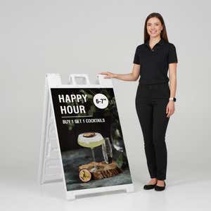 Woman standing beside a happy hour A-frame sign for scale