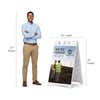 Construction now hiring A-frame sign shown with size dimensions beside a man