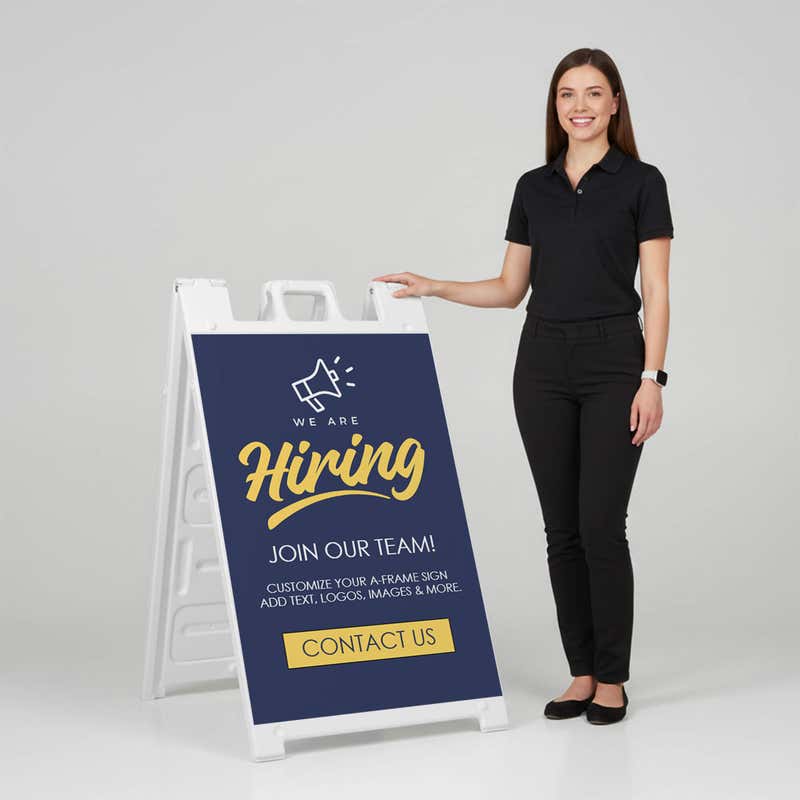 Woman standing beside a blue now hiring A-frame sign for scale