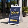 Blue now hiring A-frame sidewalk sign displayed in front of a business