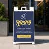Blue now hiring A-frame sidewalk sign displayed in front of a business