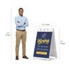 Blue now hiring A-frame sign shown with size dimensions beside a man