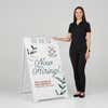 Woman standing beside a floral now hiring A-frame sign for scale