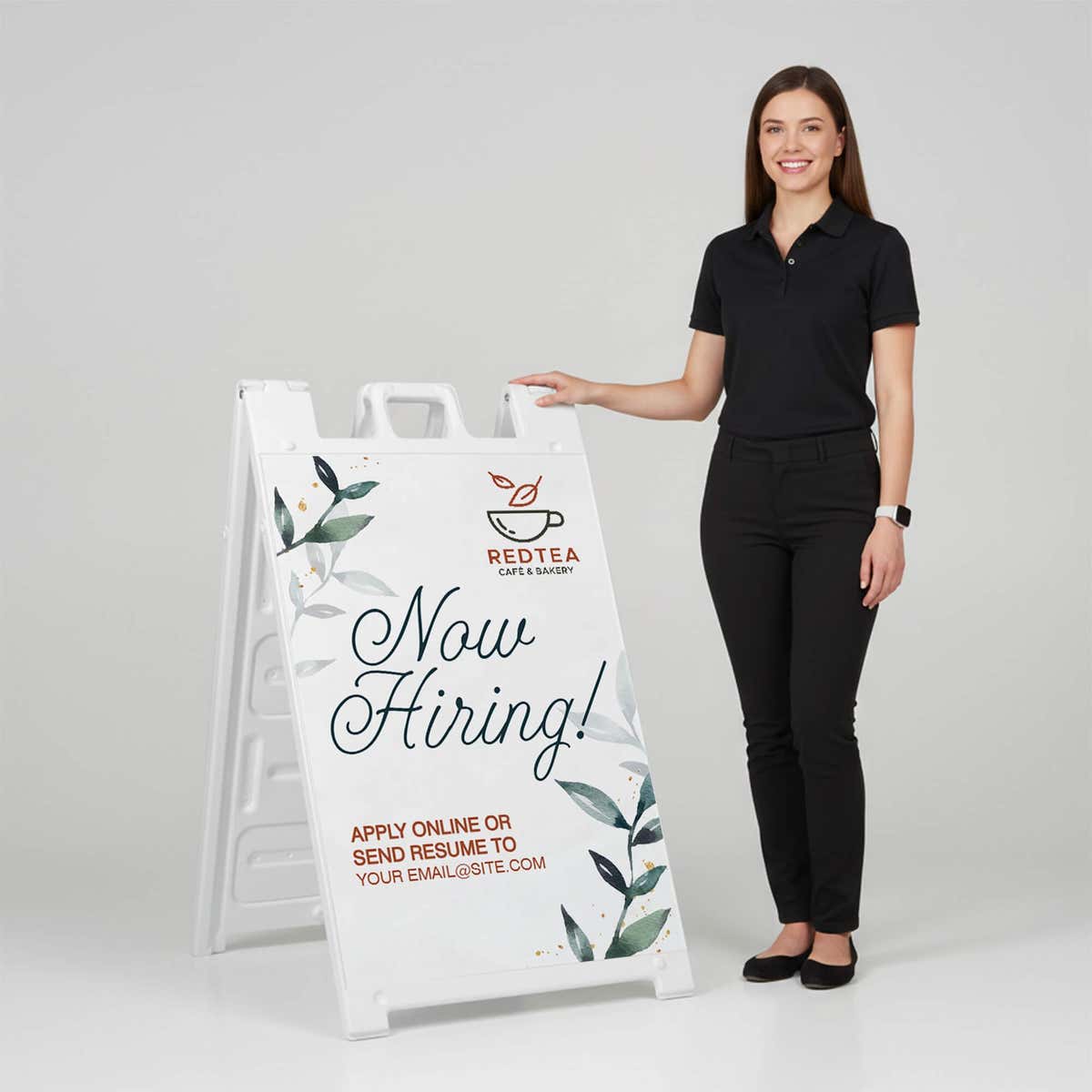 Woman standing beside a floral now hiring A-frame sign for scale
