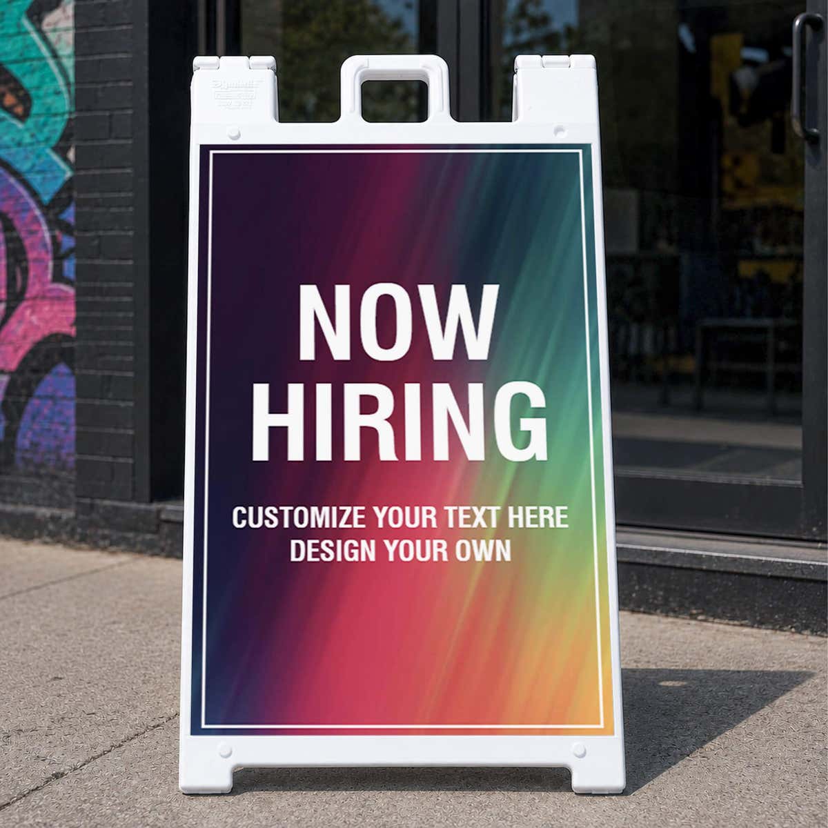 Rainbow now hiring A-frame sidewalk sign displayed in front of a business