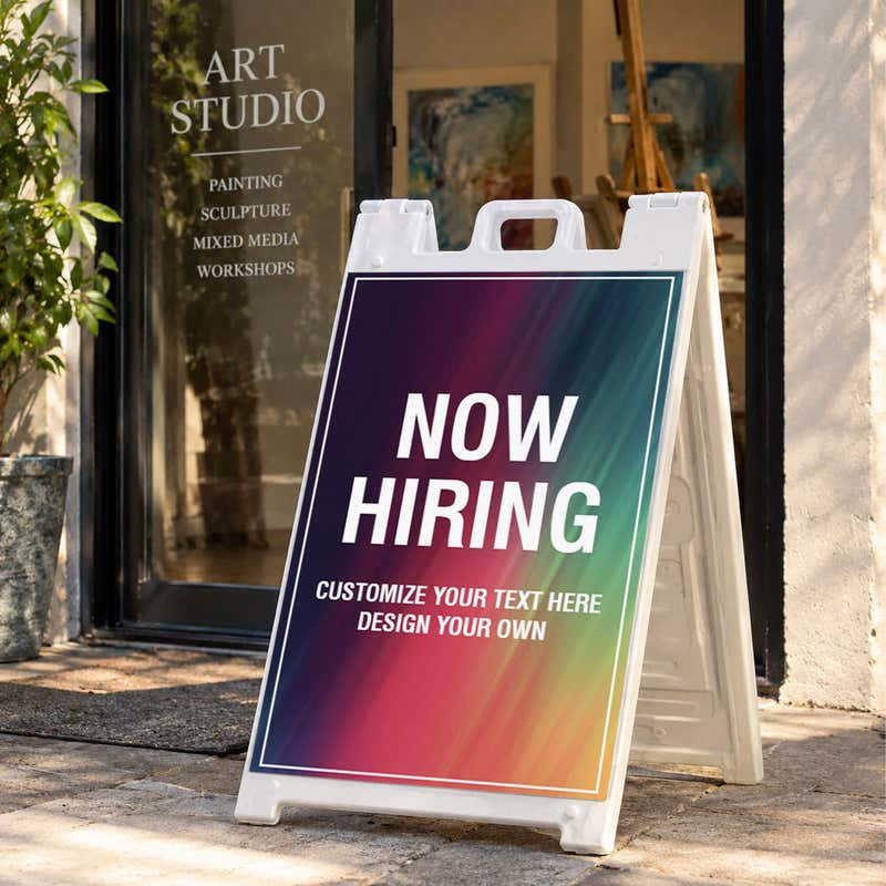 Rainbow now hiring A-frame sidewalk sign displayed in front of a business