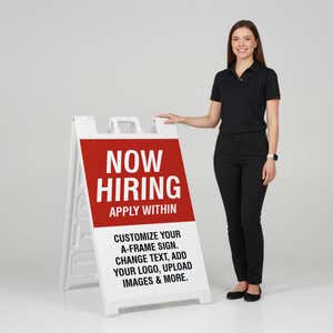 Woman standing beside a red now hiring A-frame sign for scale
