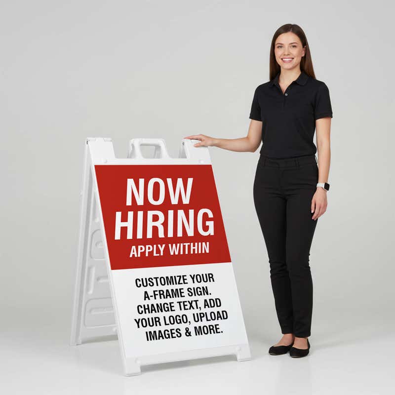 Woman standing beside a red now hiring A-frame sign for scale