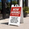 Red now hiring A-frame sidewalk sign displayed in front of a business
