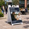 Serif now hiring A-frame sign on a college campus walkway
